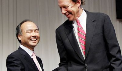 Softbank Corp. President Masayoshi Son (left) and Sprint Nextel Corp. Chief Executive Dan Hesse shake hands Monday after a deal was reached for Softbank to acquire 70 percent of Sprint for $20.1 billion in the largest ever foreign acquisition by a Japanese company. (Associated Press)