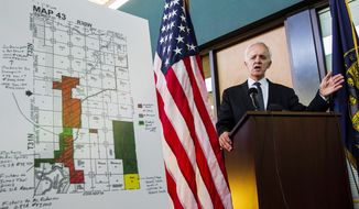Democratic former Sen. Bob Kerrey, who is seeking to return to the Senate, at a news conference in Omaha, Neb., on Monday unveils a new television attack ad that focuses on the story of a now-deceased couple who were sued by Mr. Kerrey’s Republican opponent and her husband in a land dispute in 1995. (Associated Press)