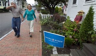 Joe Galli jokingly covers his face while walking with his wife, Thyra, by an Obama/Biden sign in front of a neighbor&#39;s home, Friday, Oct. 5, 2012, in Portsmouth, N.H. (AP Photo/Robert F. Bukaty)