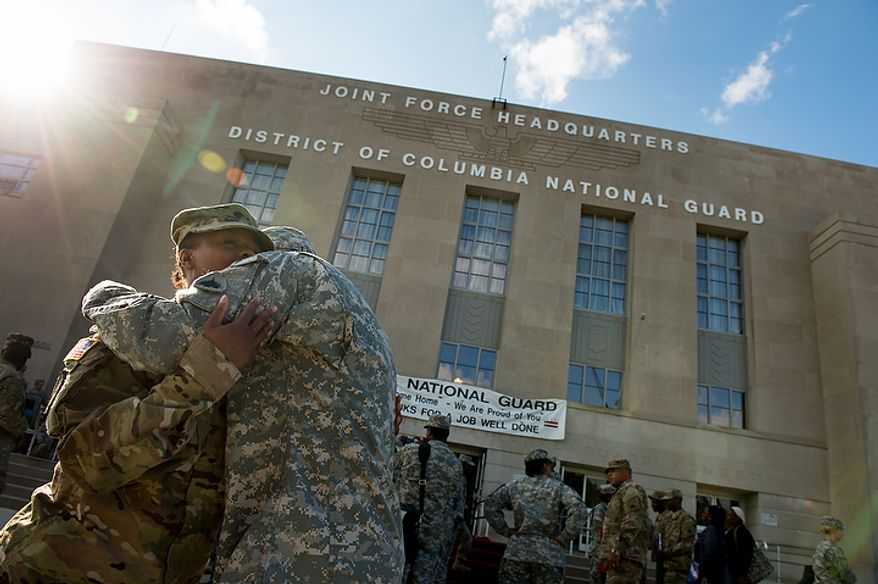 Spc. Antevia Irvin, left, one of the 70 D.C. Army National Guard soldiers with the 273rd military police company returning from Bagram Air Base, Afghanistan after 10 months hugs Spc. Kenneth Larigey following a welcome home ceremony held in front of the D.C. Armory, Washington, D.C., Tuesday, October 16, 2012. (Andrew Harnik/The Washington Times)