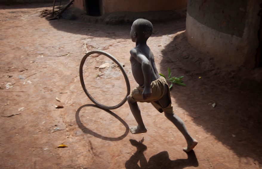**FILE** Children play April 27, 2012, at a former camp for displaced persons most of whom have now returned to their villages, in Bobi, near Gulu, Uganda. Some locals in Gulu have other concerns that complicate the military mission of forces now hunting for Lord's Resistance Army (LRA) leader Joseph Kony, such as the fear of reprisal attacks if they are thought to be helping the authorities find him, or concerns that troops hunting him will not be able to distinguish between the regular LRA fighters and their abducted children. (Associated Press)