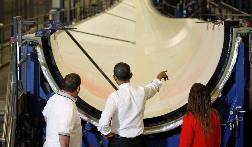 President Obama gets a look at a wind turbine blade with TPI Composites workers Larry Crady and Dajeane Spencer during a May 2012 tour of the plant in Newton, Iowa. (Associated Press) **FILE**