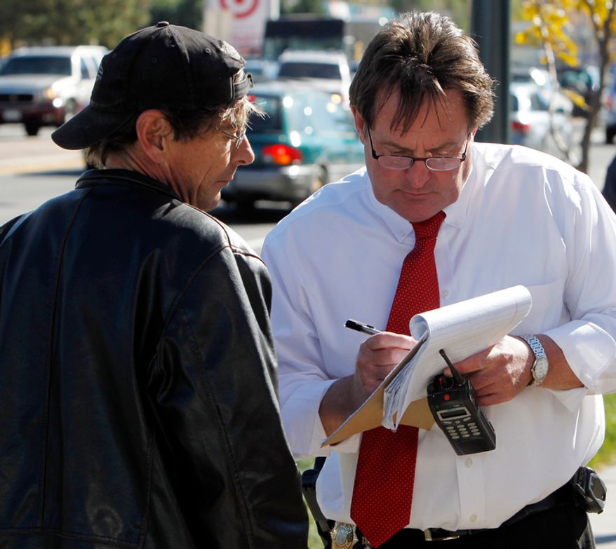 Denver Police Detective Randy Denison, right, takes a statement from Scott Christiansen at Fero's Bar and Grill in Denver on Wednesday, Oct. 17, 2012, where the bodies of a man and four women were discovered after firefighters extinguished a fire at the bar early in the morning. Police think the blaze was set to cover up the slayings. Christiansen says he was a regular customer at the bar. (AP Photo/Ed Andrieski)