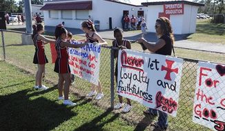** FILE ** The cheerleaders of Kountze Middle School use their faith-based signs at the middle school football game held at Kountze High School on Thursday, Sept. 20, 2012, in Kountze, Texas. (AP Photo/The Beaumont Enterprise, Randy Edwards)