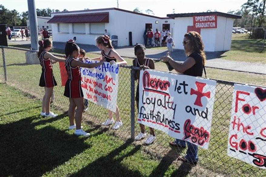 ** FILE ** The cheerleaders of Kountze Middle School use their faith-based signs at the middle school football game held at Kountze High School on Thursday, Sept. 20, 2012, in Kountze, Texas. (AP Photo/The Beaumont Enterprise, Randy Edwards)