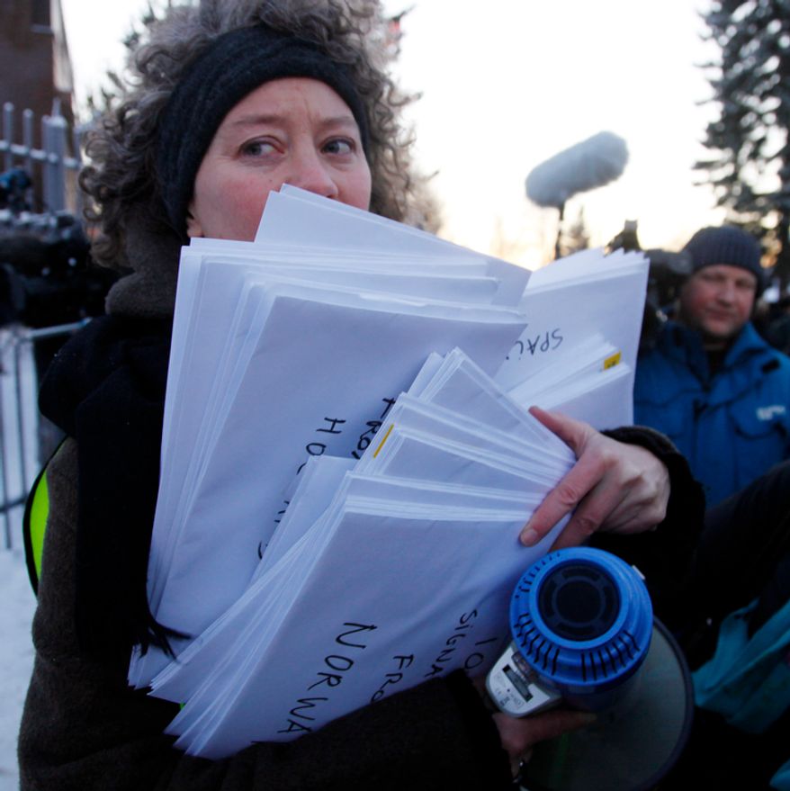A representative of Amnesty International holds petitions signed by 100,000 people around the world to demand the freedom of Nobel peace laureate Liu Xiaobo Thursday Dec. 9, 2010 outside te Chinese Embassy in Oslo, Norway. A day before the Nobel committee honors Liu, an imprisoned Chinese dissident with its peace prize, China ratched up the rhetoric calling the award "an interference" in its internal affairs. (AP Photo/John McConnico)