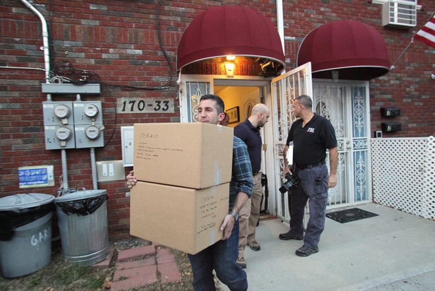 Law enforcement officials remove boxes of potential evidence from the New York home where Quazi Mohammad Rezwanul Ahsan Nafis was staying, Wednesday, Oct. 17, 2012. Nafis was arrested in an FBI sting operation earlier in the day after attempting to blow up a fake car bomb outside the Federal Reserve building in Manhattan, authorities said. (AP Photo/Newsday, Howard Schnapp) NYC OUT; NO SALES