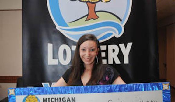 In this photo provided by the Michigan Lottery, Amanda Clayton holds her $1 million lottery check. The state says Clayton who won a $1 million lottery prize but continued to get food stamps has been removed from a food assistance program. (AP Photo/Courtesy Michigan Lottery via Detroit Free Press)  DETROIT NEWS OUT; AOL OUT