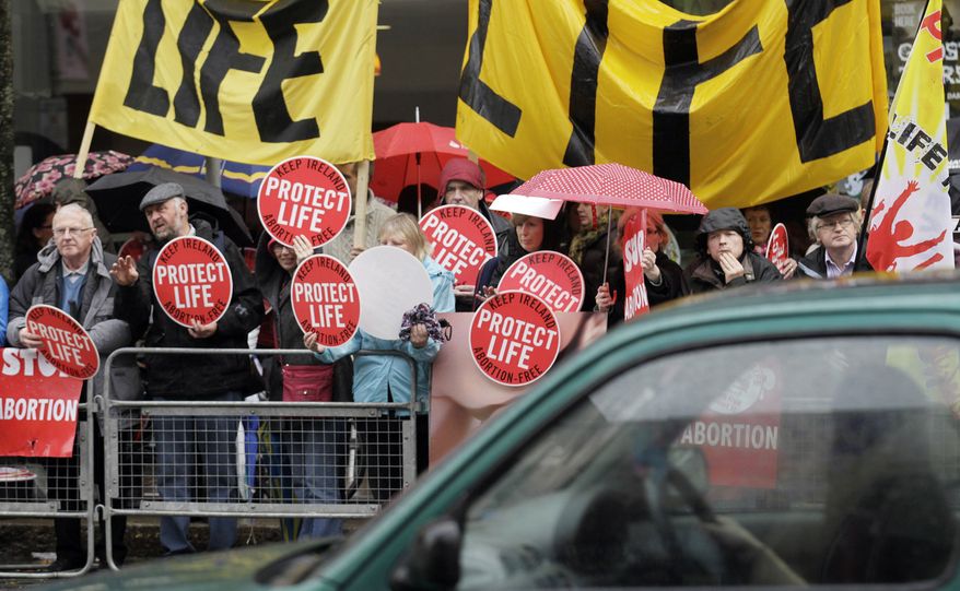 Protesters opposed to abortion hold placards outside the Marie Stopes clinic in Belfast on Thursday. The center plans to offer the abortion pill to women less than nine weeks pregnant if they’re at risk of death or long-term health damage from the pregnancy. (Associated Press)