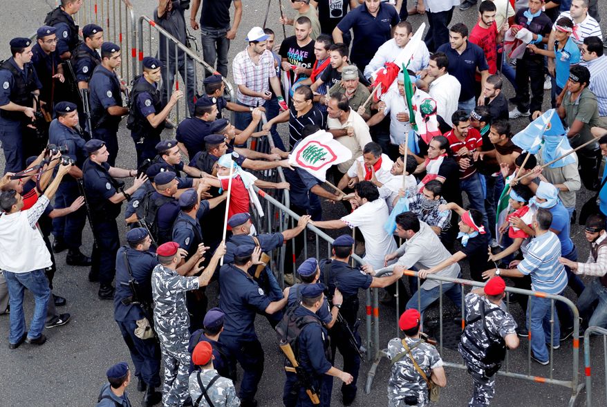 Police and protesters clash after the funeral of Brig. Gen. Wissam al-Hassan in Beirut on Sunday. Clashes erupted after the funeral for Gen. al-Hassan, who was a powerful opponent of Syria in Lebanon. He was buried in Martyrs Square in Beirut near former Prime Minister Rafik Hariri, who was killed in 2005. (Associated Press)