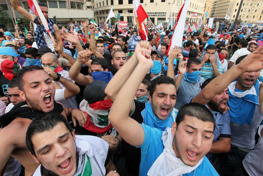 Protesters chant slogans against the Lebanese government in Beirut on Sunday, Oct. 21, 2012, after the funeral of Brig. Gen. Wissam al-Hassan, who was assassinated on Friday in a car bombing. (AP Photo/Bilal Hussein)