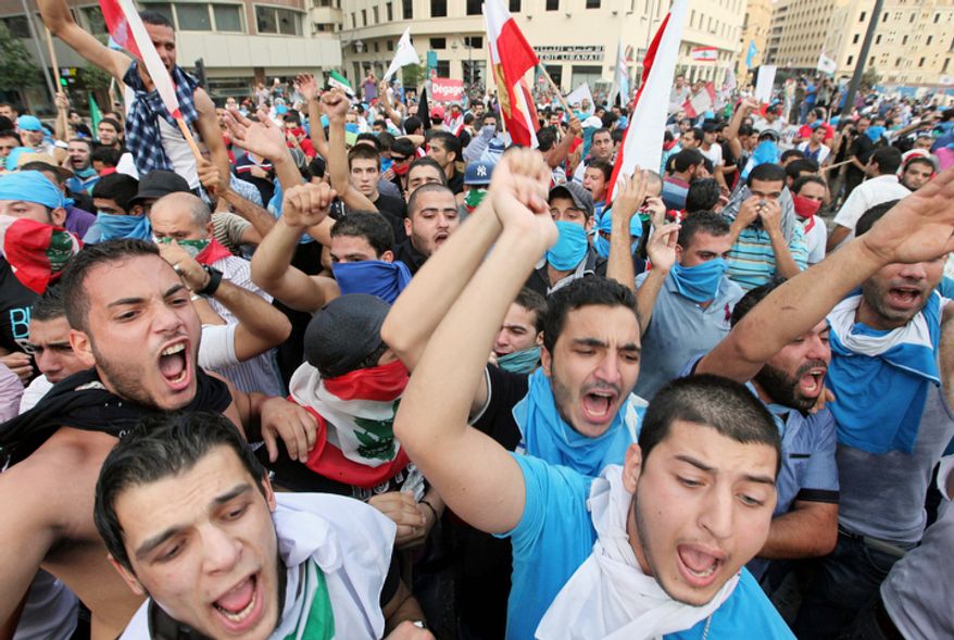 Lebanese protesters chant slogans against the Lebanese government after the funeral of Brig. Gen. Wissam al-Hassan, who was assassinated on Friday by a car bomb in Beirut, Lebanon, Sunday Oct. 21, 2012. Lebanese soldiers fired guns and tear gas to push back hundreds of protesters who broke through a police cordon and tried to storm the government headquarters in Beirut. The enraged crowd came from the funeral of a top Lebanese intelligence official assassinated in a massive car bombing. (AP Photo/Bilal Hussein)