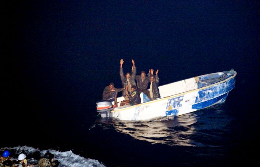 **FILE** This photo released by the French Navy shows pirates holding their hands up to soldiers (left) of the French vessel La Somme early Oct. 7, 2009, off the Somalia coast. Somali pirates in two skiffs fired on a French navy vessel after apparently mistaking it for a commercial boat, the French military said. The French ship gave chase and captured five suspected pirates. (Associated Press/Olivier Amalvict/ECPAD/French Navy)