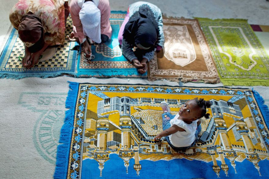 ASSOCIATED PRESS PHOTOGRAPHS
Christine Brazile sits on a prayer mat as relatives pray during a Friday prayer service last month at the Al-Fattah Mosque. Islam, a new religion in Haiti, is gaining adherents. Port au Prince has t least five mosques, a Muslim parliament member and a nightly local television program devoted to Islam.