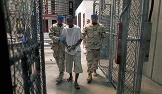 A detainee is escorted from a class in “life skills” inside Camp 6, a medium-security facility at Guantanamo Bay that allows interaction and recreation. The U.S. guards are trained in cultural sensitivity to help ensure safe and normal operations. (Associated Press)