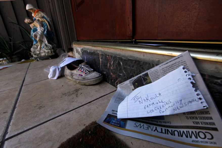 A religious figure, shoes and a newspaper lie at the steps of the suburban Los Angeles home believed to be that of filmmaker Nakoula Basseley Nakoula, Friday, Sept. 14, 2012. Federal authorities have identified Nakoula, a self-described Coptic Christian, as the key figure behind "Innocence of Muslims," a film denigrating Islam and the Prophet Muhammad that ignited mob violence against U.S. embassies across the Middle East. (AP Photo/Reed Saxon)