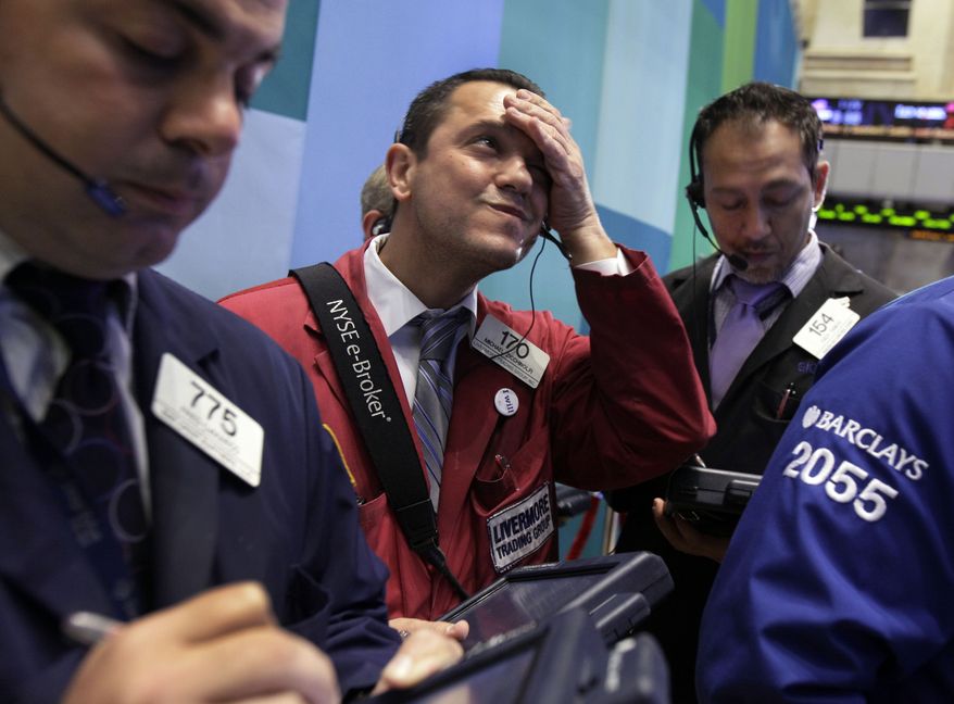 Trader Michael Zicchinolfi (center) works on the floor of the New York Stock Exchange on Monday, Oct. 22, 2012. (AP Photo/Richard Drew)