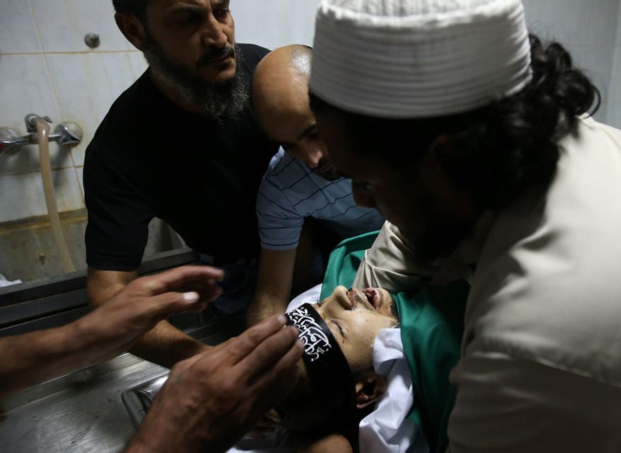 Mourners prepare the body of Palestinian Ahmad Queider, 20, for burial at a hospital morgue in the Sunni neighborhood of Tarik al-Jadida in Beirut on Oct. 23, 2012. Queider was killed Monday as he rode his motorcycle during an exchange of gunfire between Lebanese troops and gunmen. (Associated Press)