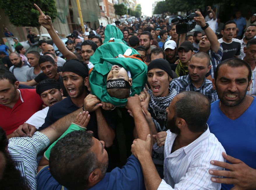 Mourners shout religious slogans Oct. 23, 2012, in the Sunni neighborhood of Tarik al-Jadida in Beirut during the funeral procession of Palestinian Ahmad Queider, 20, who was killed the day before as he rode his motorcycle during an exchange of gunfire between Lebanese troops and gunmen. (Associated Press)
