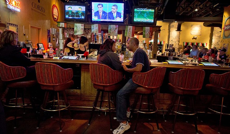 Bryan Gieszler (right) and Maria Sullivan talk while watching the presidential debate at a restaurant in Las Vegas on Monday, Oct. 22, 2012. President Obama and Republican candidate Mitt Romney squared off in the third and final debate, focusing primarily on foreign policy, before the general election on Nov. 6. (AP Photo/Julie Jacobson)