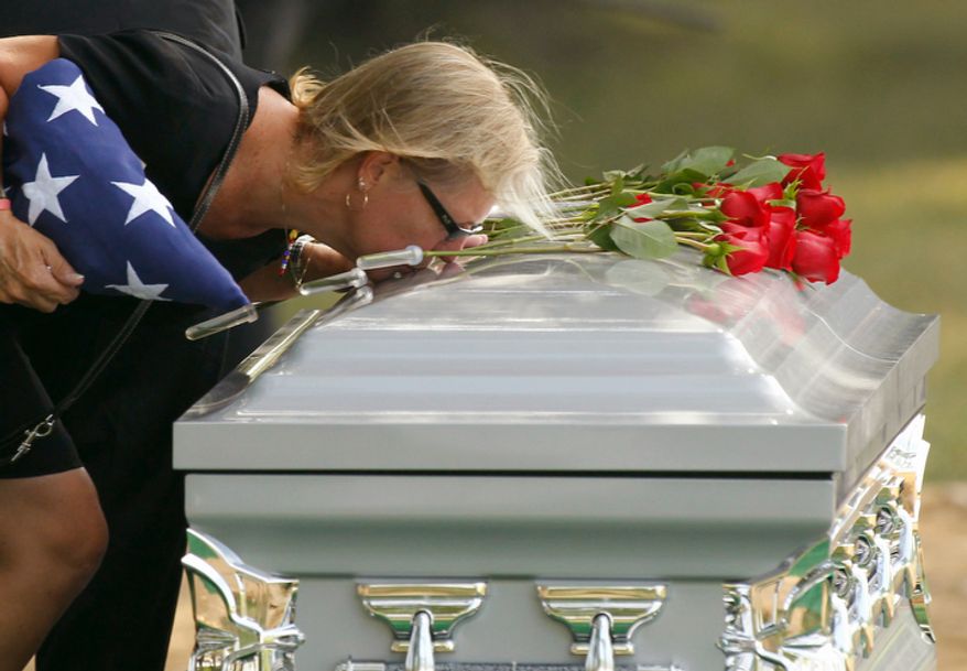 Tammy O'Brien kisses the casket one last time after services for her son Marine Lance Corporal Nicholas O'Brien, Tuesday, June 28, 2011, at Arlington National Cemetery in Arlington, Va. O'Brien died June 9 from an IED (improvised explosive device) in Helmand province in southern Afghanistan. (AP Photo/Alex Brandon)