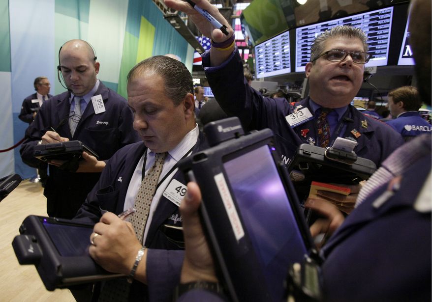 Trader John Panin (right) works Oct. 23, 2012, on the floor of the New York Stock Exchange. (Associated Press)