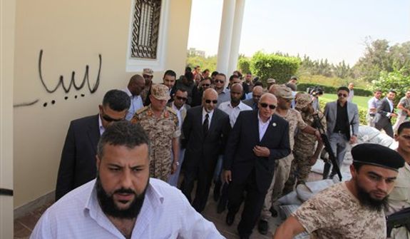 **FILE** President Mohammed el-Megarif (center) visits the U.S. Consulate in Benghazi, Libya, on Sept. 14, 2012, to express sympathy for the death of U.S. Ambassador Chris Stevens and his colleagues in the Sept. 11 attack on the consulate. (Associated Press)