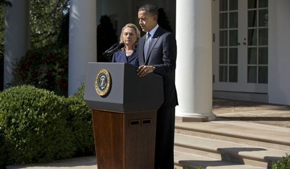 **FILE** Secretary of State Hillary Clinton looks on as President Obama delivers a statement Sept. 12, 2012, in the Rose Garden of the White House on the death of Christopher Stevens, U.S. ambassador to Libya. (Associated Press)