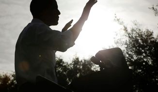 A silhouetted President Obama gestures during a morning campaign event at Ybor City Museum State Park on Thursday in Tampa, Fla. Meanwhile, in Cleveland, another battleground state, Ohio, his campaign is deluging the airwaves with ads. (Associated Press)