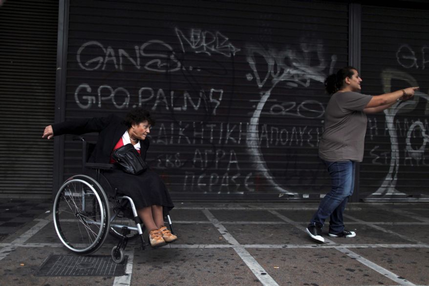 A woman with disabilities takes part in a march against the Greek government's new austerity measures outside the Labor Ministry in central Athens on Tuesday, Oct. 23, 2012. Greece is negotiating with its creditors on a new austerity program for the next two years. Until an agreement is struck, Athens will not receive a desperately needed new loan originally scheduled for June. Without it, the government will run out of money on Nov. 16. (AP Photo/Petros Giannakouris)