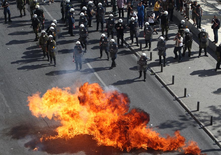 Protesters throw gasoline bombs at riot police during a 24-hour nationwide general strike in Athens on Thursday, Oct. 18, 2012. Greece faced its second general strike in a month as workers protested over another batch of austerity measures that are designed to prevent the bankruptcy of the country. (AP Photo/Thanassis Stavrakis)