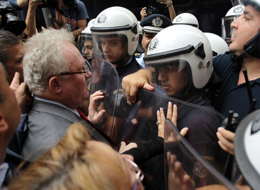Lawyers and doctors scuffle with riot police during an anti-austerity protest outside the Finance Ministry in Athens on Wednesday, Oct. 17, 2012. Civil servants and private sector workers staged a nationwide general strike on Thursday to protest new austerity measures the government is still negotiating with the debt-ridden country's international creditors. (AP Photo/Thanassis Stavrakis)