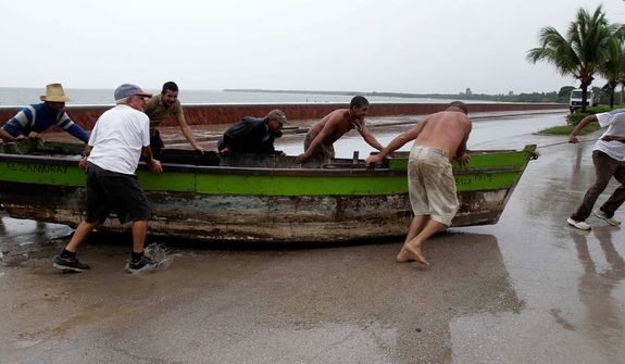 People remove a boat from the water ahead of the arrival of Hurricane Sandy in Manzanillo, Cuba, Wednesday, Oct. 24, 2012. Hurricane Sandy pounded Jamaica with heavy rain as it headed for landfall near the country&#39;s most populous city on a track that would carry it across the Caribbean island to Cuba, and a possible threat to Florida. (AP Photo/Franklin Reyes)
