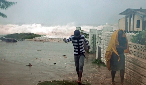 Residents evacuate their home as waves crash in the Caribbean Terrace neighborhood of eastern Kingston, Jamaica, Wednesday, Oct. 24, 2012. Hurricane Sandy pounded Jamaica with heavy rain as it headed for landfall near the country&#39;s most populous city on a track that would carry it across the Caribbean island to Cuba, and a possible threat to Florida. (AP Photo/Collin Reid)