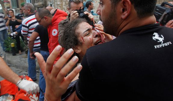 A injured woman is carried by a civilian at the scene of an explosion in the mostly Christian neighborhood of Achrafiyeh, Beirut, Lebanon, Friday Oct. 19, 2012. Lebanese Red Cross and security officials say a car bomb in east Beirut has killed at least eight people and wounded dozens in the worst blast the city has seen in years, coming at a time when Lebanon has seen a rise in tension and eruptions of clashes stemming from the civil war in neighboring Syria. (AP Photo/Hussein Malla)