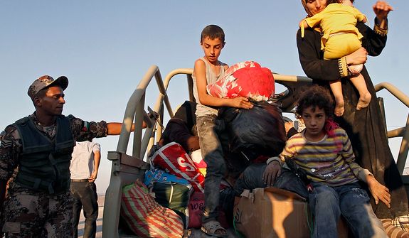 Newly arrived Syrian refugees unload their belongings after crossing the border from Tal Shehab, Syria, through the Al Yarmouk River Valley, and arriving near Ramtha, Jordan, on Saturday, Sept. 15, 2012. (AP Photo/Raad Adayleh)