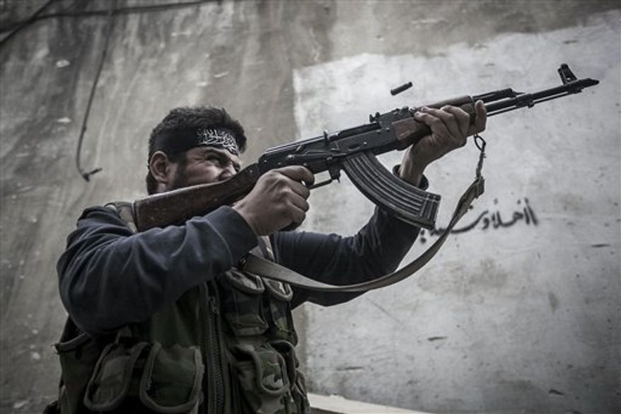 In this Wednesday, Oct. 24, 2012, photo. An Free Syrian Army fighter shoots his gun toward government troops as rebel fighters belonging to the Liwa Al Tawhid group carry out a military operation at the Moaskar front line, one of the battlefields in Karmal Jabl neighborhood, in Aleppo, Syria. (AP Photo/Narciso Contreras).