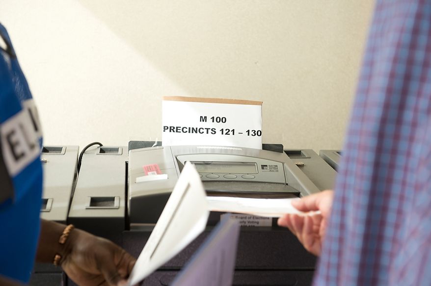 A voter slides a paper ballot into one of the voting machines at Judiciary Square in Washington on Wednesday, Oct. 24, 2012. According to site officials, some 2,400 people have voted here since Monday, when the voting opened. The District of Columbia will open seven more early-voting sites on Saturday (one in each ward), which will be open daily except Sundays until Nov. 3 from 8:30 a.m. to 7 p.m. (Barbara L. Salisbury/The Washington Times)