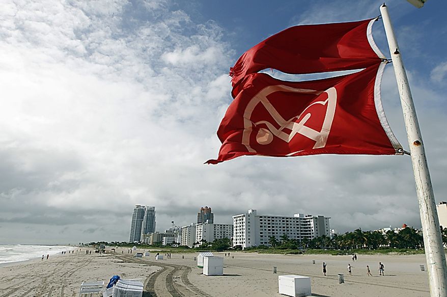 Red flags fly from a lifeguard station as Hurricane Sandy passes offshore to the east, Friday, Oct. 26, 2012, in Miami Beach, Fla. Hurricane Sandy left at least 21 people dead as it moved through the Caribbean, following a path that could see it blend with a winter storm and reach the U.S. East Coast as a super-storm next week. (AP Photo/Lynne Sladky)
