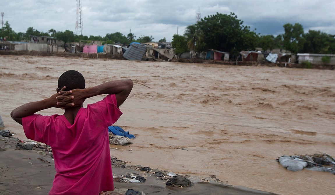 A man watches a river affected by heavy rains brought by Hurricane Sandy in Port-au-Prince, Haiti, on Oct. 25,  2012. Sandy was blamed for the death of an elderly man in Jamaica who was crushed by a boulder. Another man and two women died while trying to cross storm-swollen rivers in southwestern Haiti. (Associated Press)