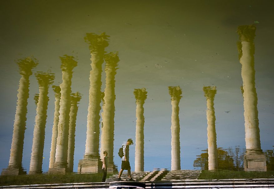 Gandulga Shuree (right) and Khulan Batsaikhan (left) both from Arlington, Va., are seen in the reflection of the pool as they visit the Capitol Columns at the National Arboretum in Washington, D.C., Tuesday, Oct. 23, 2012. The 22 Corinthian sandstone columns were among the 24 that were part of the east central portico of the US Capitol.These columns provided the backdrop for presidential inaugurations from 1829 (Andrew Jackson to 1957 (Dwight Eisenhower) and were the site of many speeches, protests and rallies. In 1958 the columns were dismantled to make way for the east front extension of the Capitol, which is adorned with marble reproductions. Restoration of the columns was made possible through the efforts of Ethel Shields Garrett and support form the Friends of the National Arboretum. (Rod Lamkey Jr./The Washington Times)