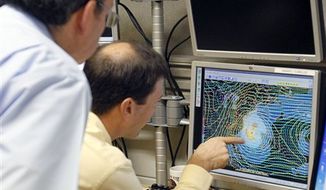 Senior hurricane specialist Dan Brown, right, points to a satellite image of Sandy to James Franklin, chief hurricane specialist, in preparation of the 11:00 EDT advisory at the National Hurricane Center in Miami, Saturday, Oct. 27, 2012. Early Saturday, the storm was about 335 miles southeast of Charleston, S.C. Tropical storm warnings were issued for parts of Florida&#39;s East Coast, along with parts of coastal North and South Carolina and the Bahamas. Tropical storm watches were issued for coastal Georgia and parts of South Carolina, along with parts of Florida and Bermuda. Sandy is projected to hit the Atlantic Coast early Tuesday. (AP Photo/Alan Diaz)