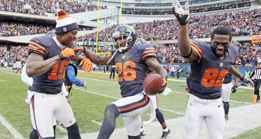 associated press
Bears cornerback Tim Jennings (26) celebrates his interception return for a touchdown Sunday with Brandon Marshall (15) and Earl Bennett. Chicago came from behind to defeat Carolina 23-22 on Robbie Gould’s 41-yard field goal as time expired. Chicago won despite allowing Jay Cutler to be sacked six times.