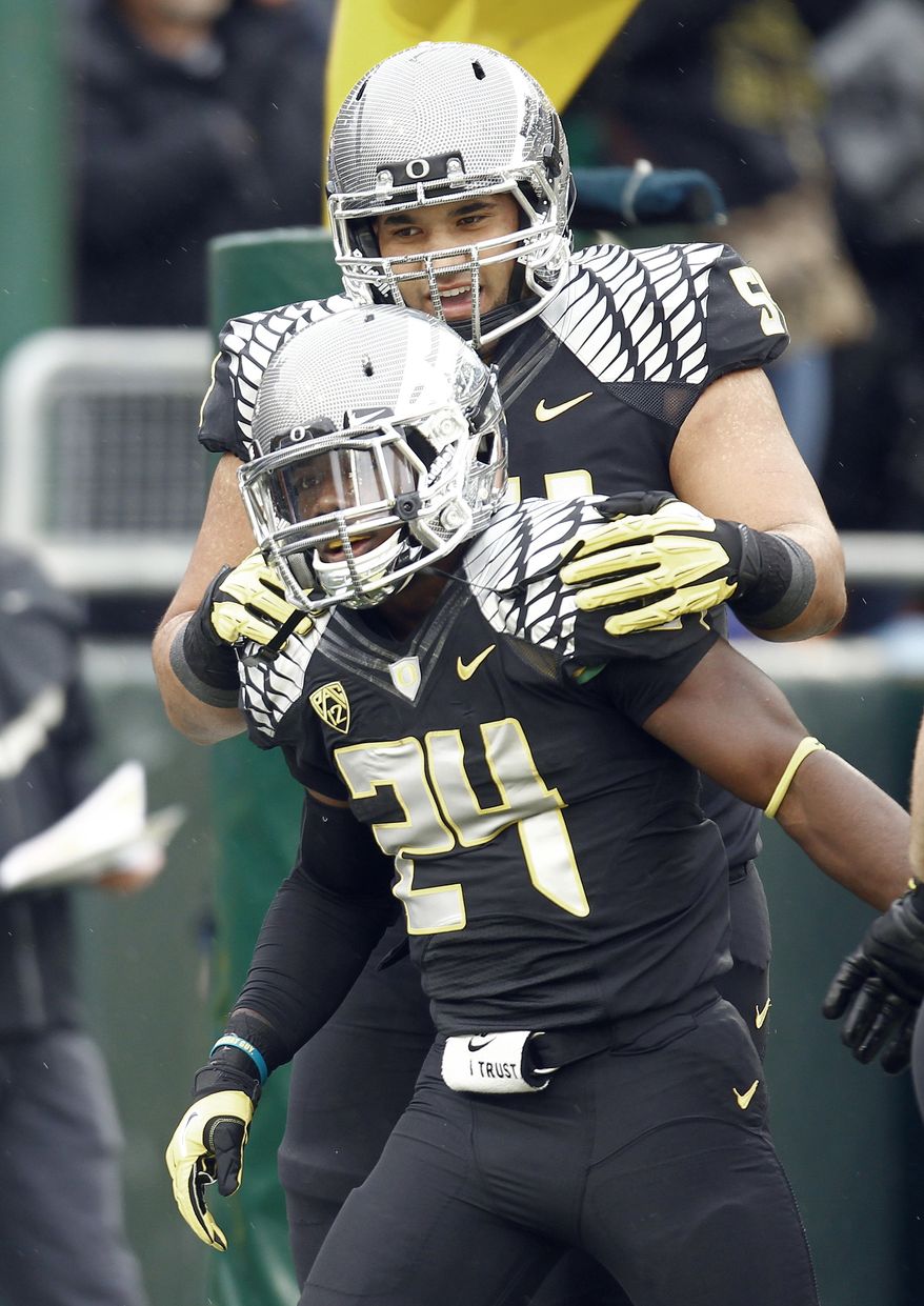 Oregon running back Kenjon Barner, front, celebrates his touchdown with teammate Axel McQuaw during the first half of an NCAA college football game against Colorado in Eugene, Ore., Saturday, Oct. 27, 2012. Barner rushed for 104 yards and two touchdowns, and No. 2 Oregon defeated Colorado 70-14. (AP Photo/Don Ryan)