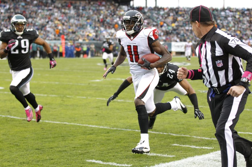 Atlanta Falcons wide receiver Julio Jones (11) scores on a 63-yard touchdown pass as Philadelphia Eagles cornerback Nnamdi Asomugha (24) goes in for the tackle during the first half of an NFL football game, Sunday, Oct. 28, 2012, in Philadelphia. (AP Photo/Mel Evans)