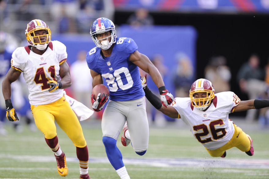 New York Giants wide receiver Victor Cruz (80) runs past Washington Redskins free safety Madieu Williams (41) and a diving cornerback Josh Wilson (26) on his way to a 77-yard game-winning touchdown late in the fourth quarter at MetLife Stadium, East Rutherford, N.J., Oct. 21, 2012. (Preston Keres/Special to The Washington Times)