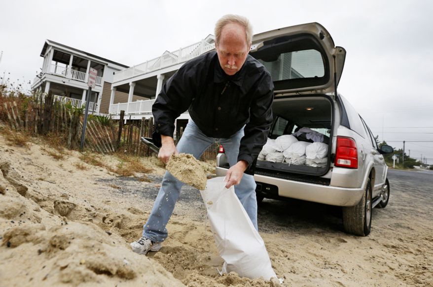 Mike Strobel fills sand bags for his business, Mike's Carpet Connection, as Hurricane Sandy bears down on the East Coast, Sunday, Oct. 28, 2012, in Fenwick Island, Del. (AP Photo/Alex Brandon)