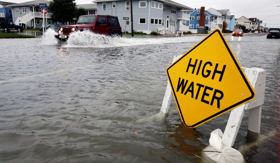 A car goes through the high water as Hurricane Sandy bears down on the East Coast, Sunday, Oct. 28, 2012, in Ocean City, Md.  Governors from North Carolina, where steady rains were whipped by gusting winds Saturday night, to Connecticut declared states of emergency. (AP Photo/Alex Brandon)