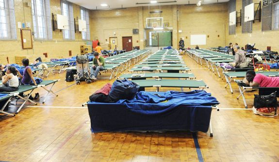 A public shelter in Seward Park High School on the lower east side begins to fill in preparation of the storm in New York.  (AP Photo/ Louis Lanzano)