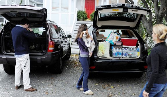 The Flaven family pack up their cars before evacuating the area in Fairfield, Conn., Sunday, Oct. 28, 2012. Mandatory evacuations have been ordered for Sunday in parts of Bridgeport, Fairfield, East Haven, Old Lyme, Old Saybrook and Branford. Voluntary evacuations are being urged in parts of Westport and New London. (AP Photo/Jessica Hill)